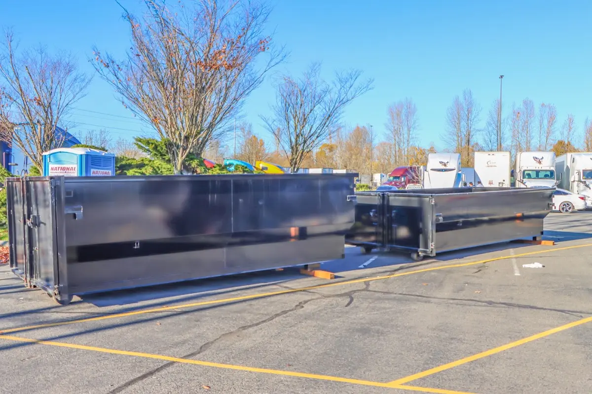 Professional dumpster rental service with roll-off container on residential driveway in Rye